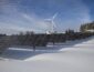 solar panels on snow with windmill under clear day sky